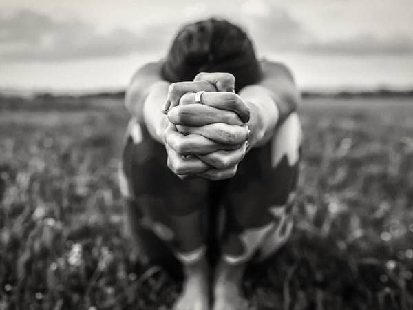 woman on ground hands clasped 